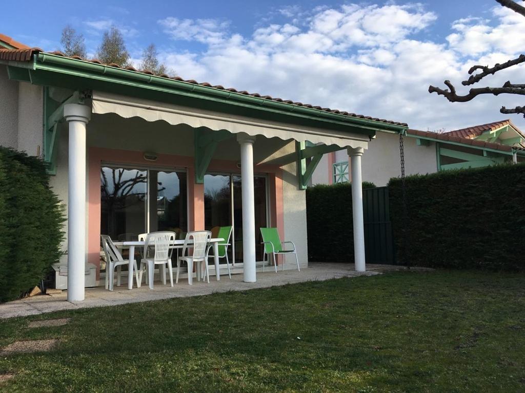 eine Terrasse mit Stühlen und Tischen auf einem Haus in der Unterkunft Biscarrosse Lac Villa 2 chambres et jardin à Navarrosse in Biscarrosse