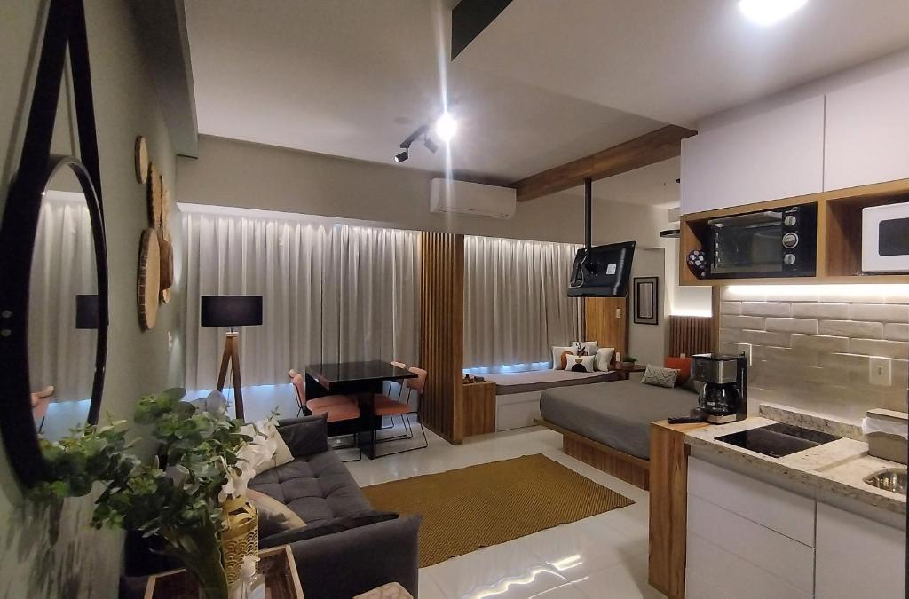 a living room with a couch and a table at Lindo studio na área central de Poços in Poços de Caldas