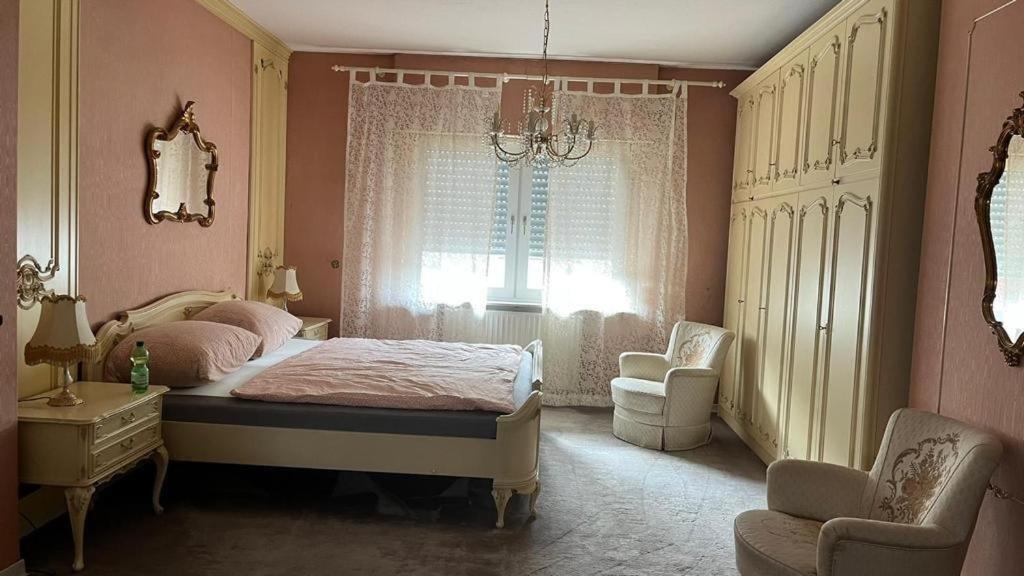- une chambre avec un lit, une chaise et une fenêtre dans l'établissement Pension Highway Ferienwohnung Osnabrück, à Osnabrück