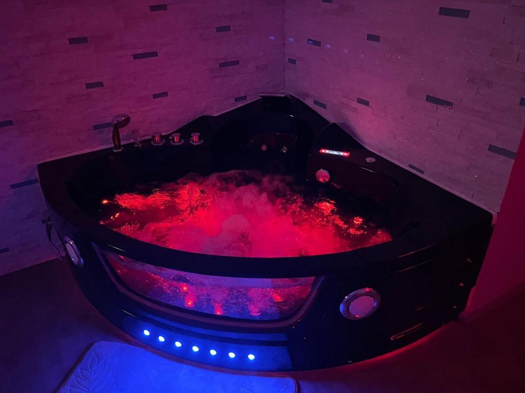 een hot tub met rode lava in een kamer bij Love Room & Spa Jacuzzi in Fleury-les-Aubrais
