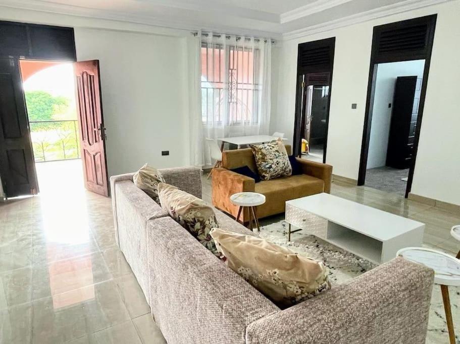 a living room with two couches and a table at Bright & Beautiful 2-Bed Apartment, Central Kumasi in Kumasi