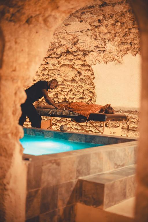 Un homme debout à côté d'un lit dans une grotte dans l'établissement La Maison des Lamanon, à Salon-de-Provence