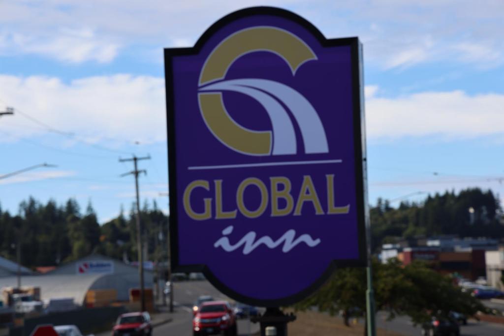 a sign for a global gas station on a road at Global Inn in Coos Bay