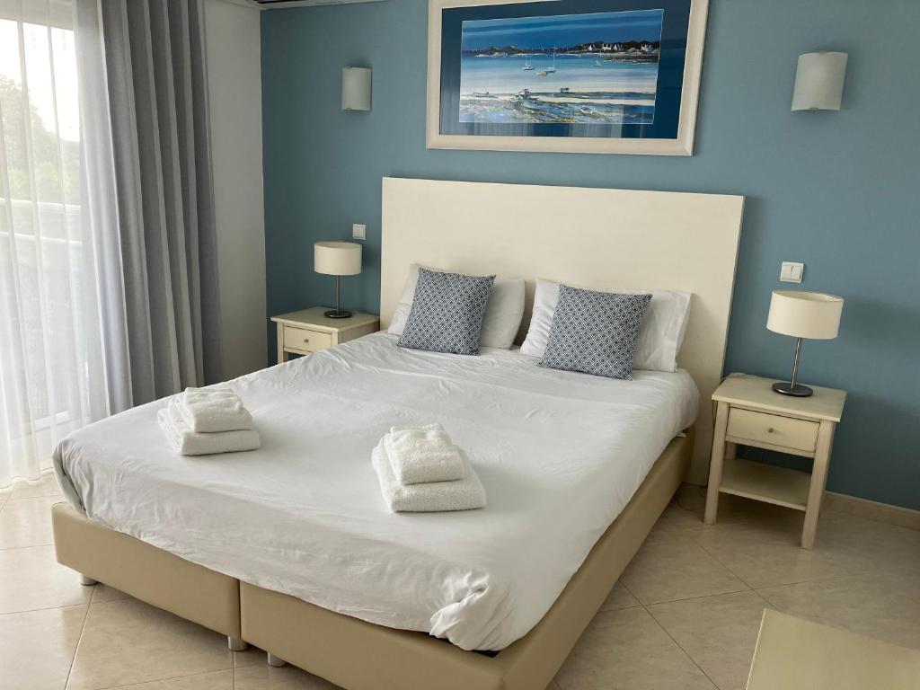 アルヴォルにあるApartamento Vila Marachiqueのベッドルーム1室(白い大型ベッド1台、ナイトスタンド2台付)