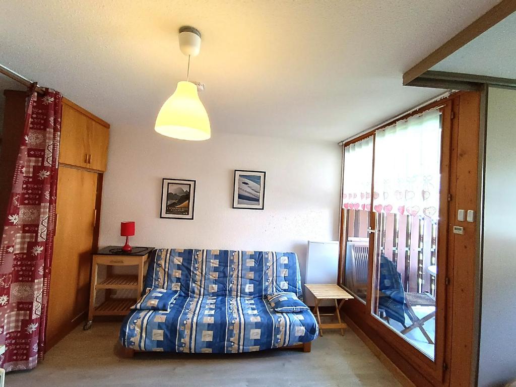 een slaapkamer met een blauw bed en een raam bij Appartement Saint-François-Longchamp, 2 pièces, 5 personnes - FR-1-635-122 in Saint-François-Longchamp