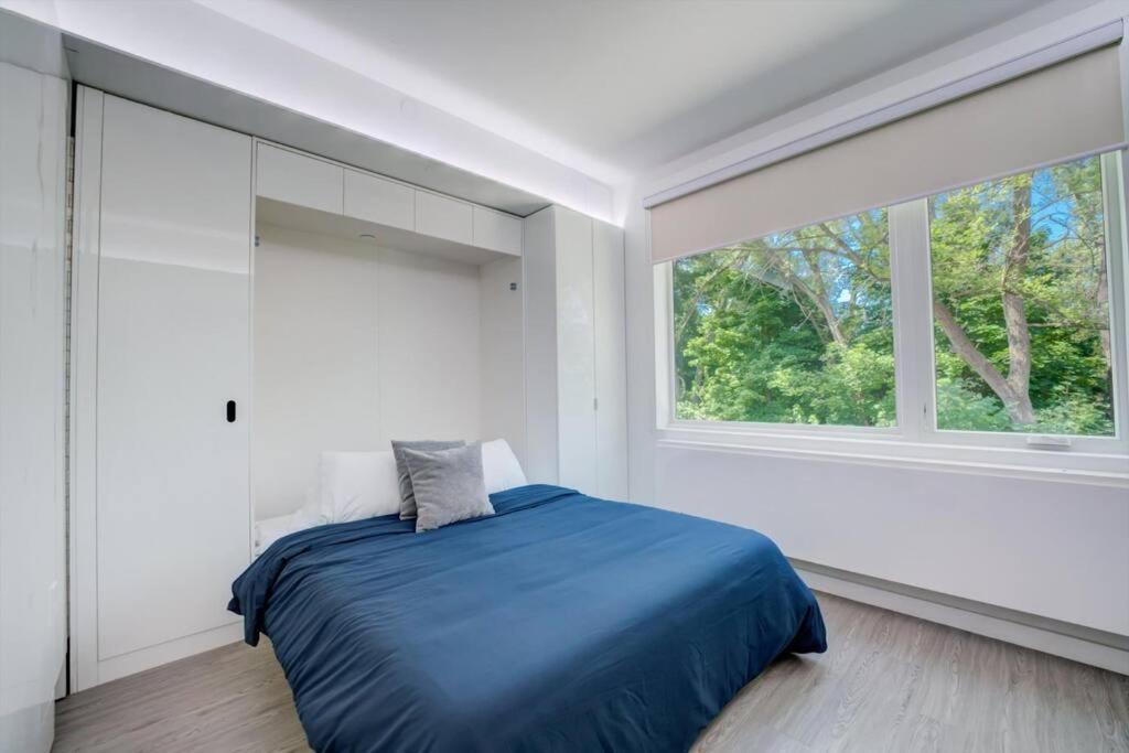 a bedroom with a blue bed and a window at KCM Tremont Oaks Apartments 5 in Cleveland