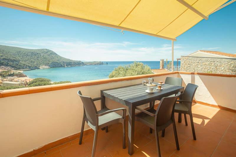 un tavolo e sedie su un balcone con vista sull'oceano di Giglio Blu 1 a Campese