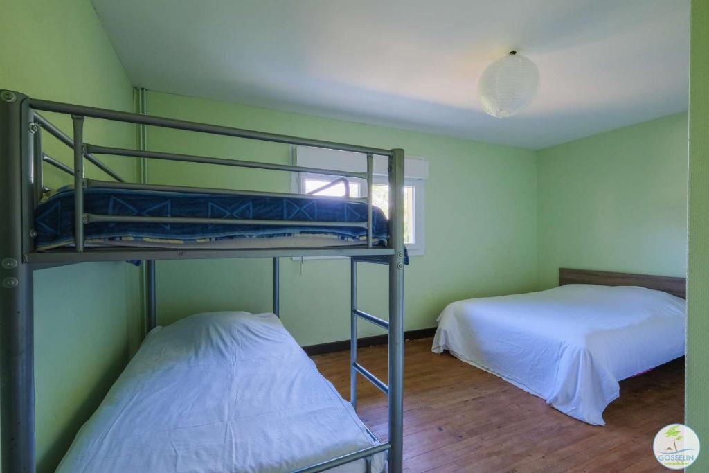 Cette chambre comprend deux lits superposés et un lit. dans l'établissement Sanguinet Appartement 3 chambres proche du lac, à Sanguinet