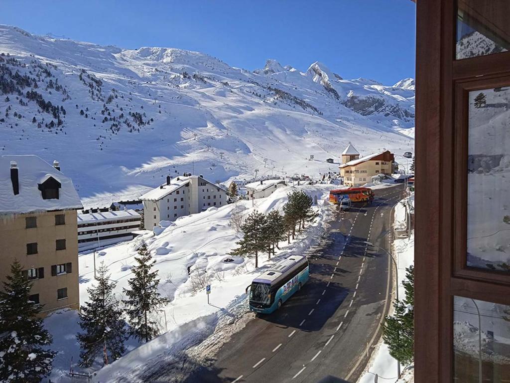 a view of a snowy mountain from a window at Apartamentos Candanchu 3000 in Candanchú