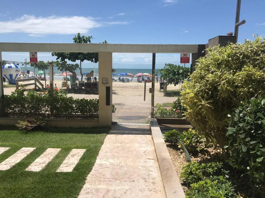 einen Fußweg, der zu einem Strand mit Sonnenschirmen führt in der Unterkunft Apto com ótima localização, centro de Meia Praia in Itapema