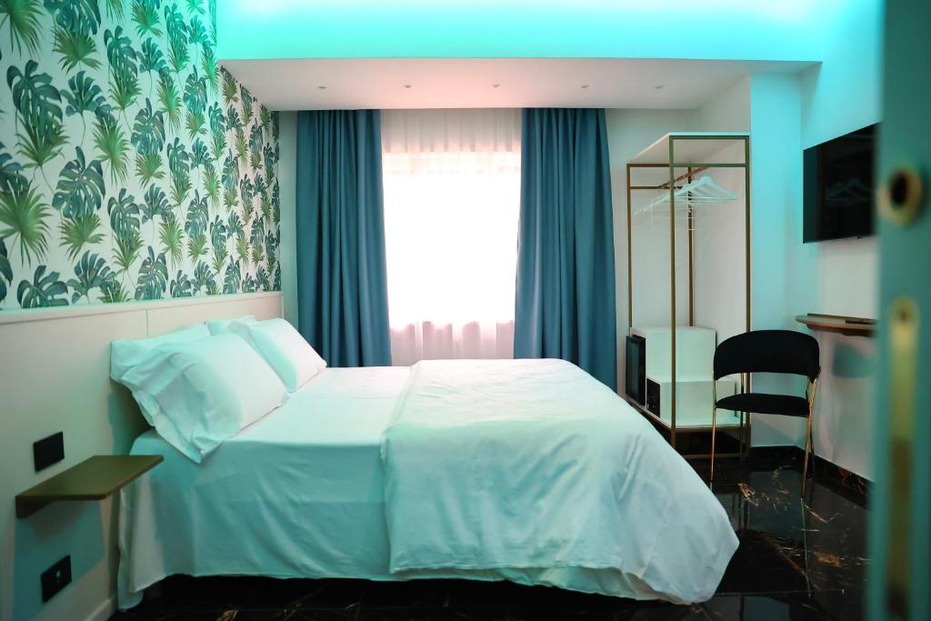 een slaapkamer met een wit bed en een raam bij Hotel Max in Aversa