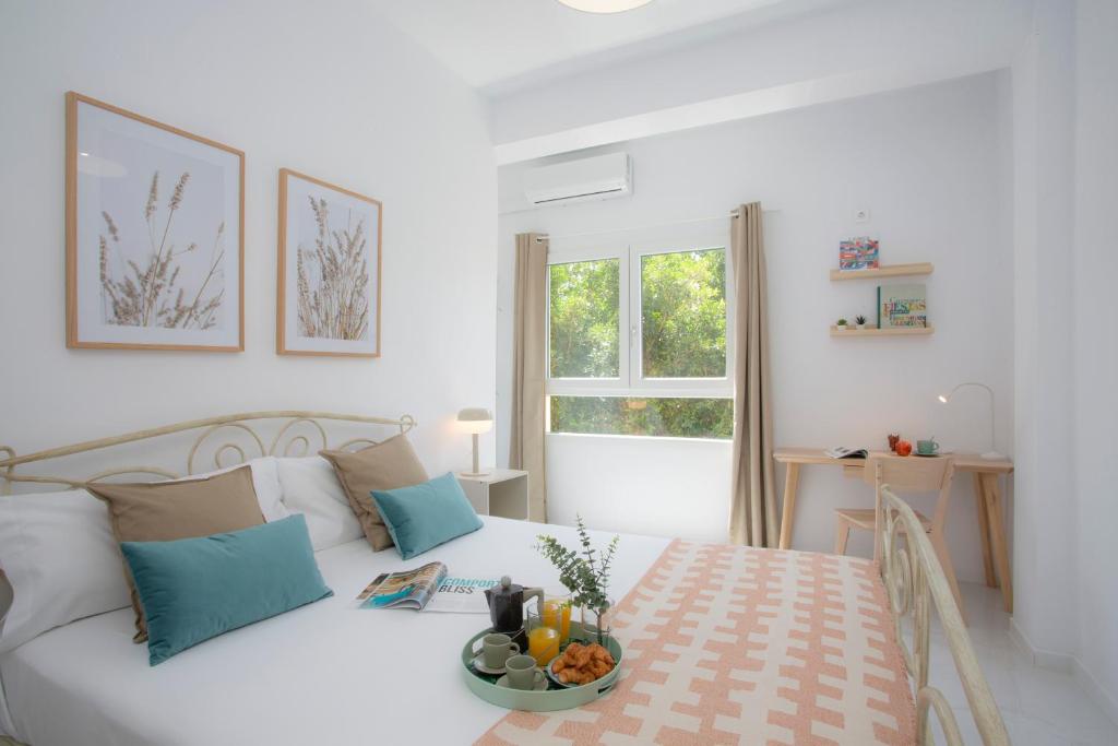 a white bedroom with a bed with a bowl of fruit on it at SingularStays Tinglado in Valencia