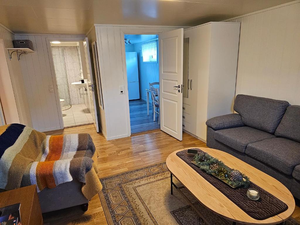 uma sala de estar com um sofá e uma mesa em Cozy home em Gravdal