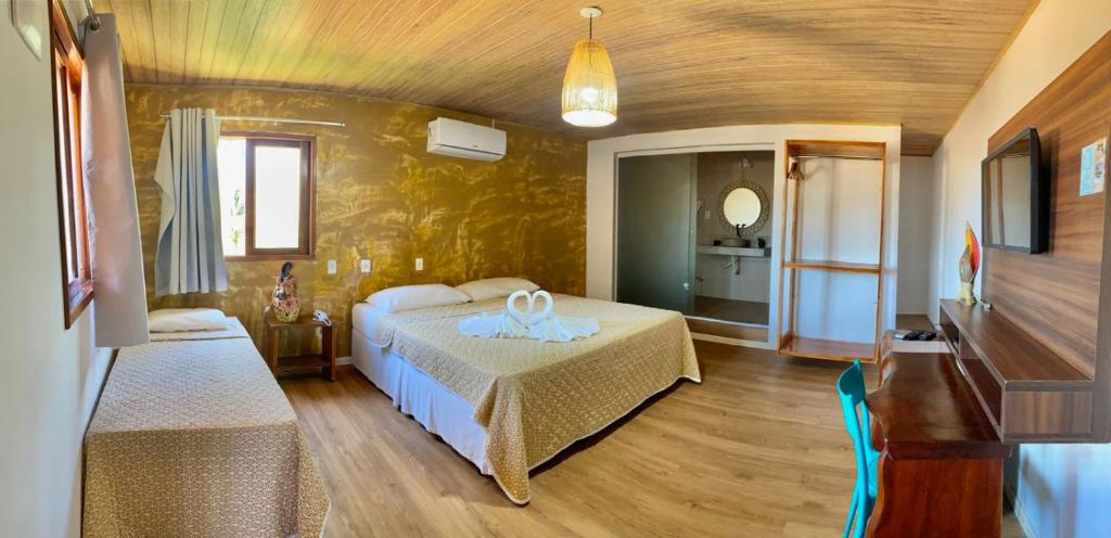 ein Schlafzimmer mit einem Bett und einem Tisch in einem Zimmer in der Unterkunft Pousada Yapara-Tyba in Japaratinga