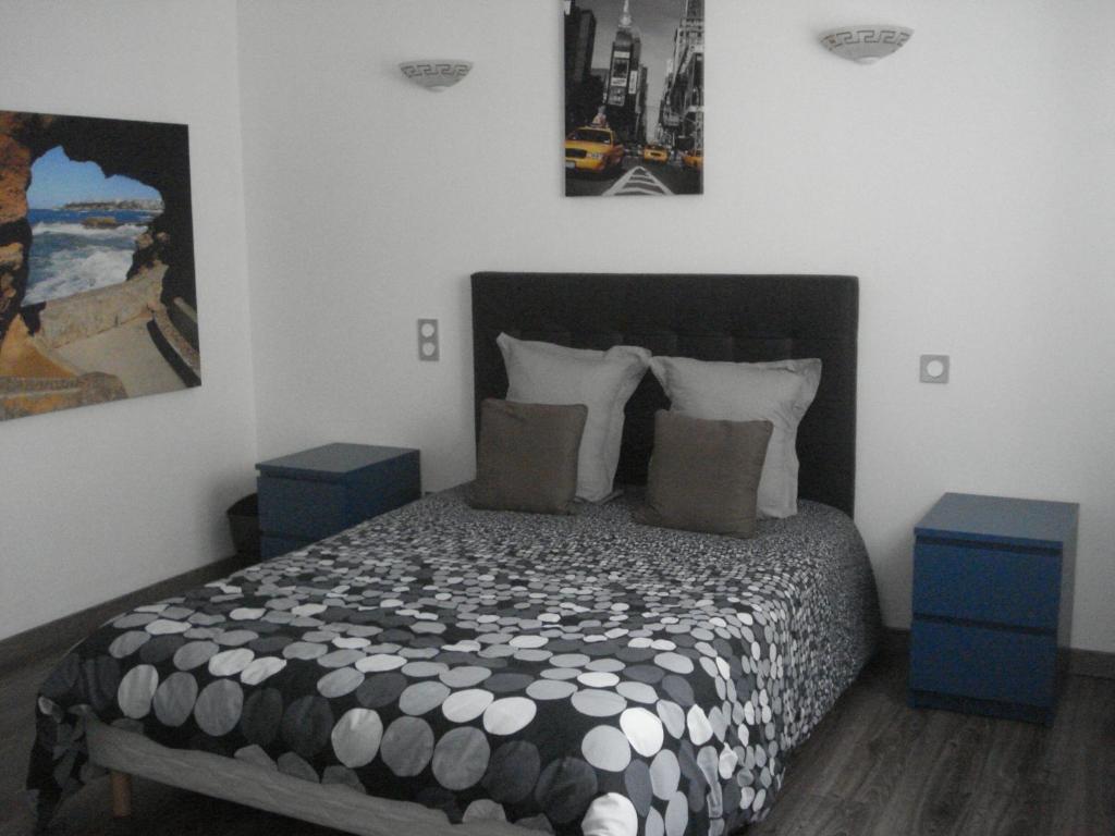 a bedroom with a bed with two tables and a picture on the wall at Gite Izaxulo in Saint-Jean-Pied-de-Port