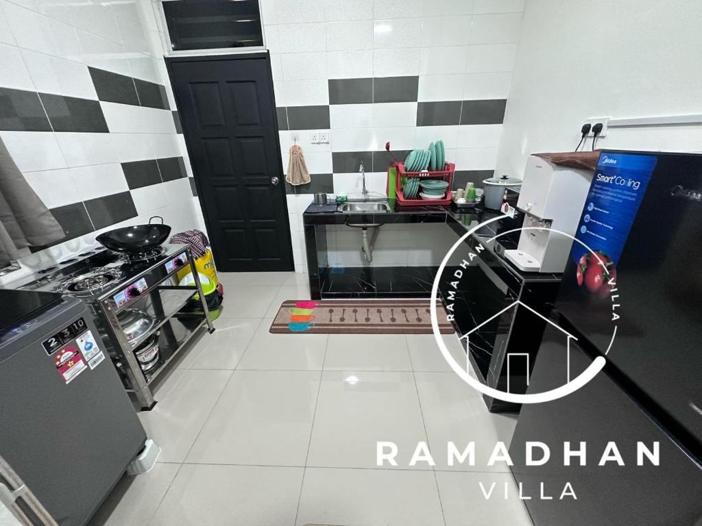 uma cozinha com uma cozinha a preto e branco em Ramadhan Villa PD em Porto Dickson