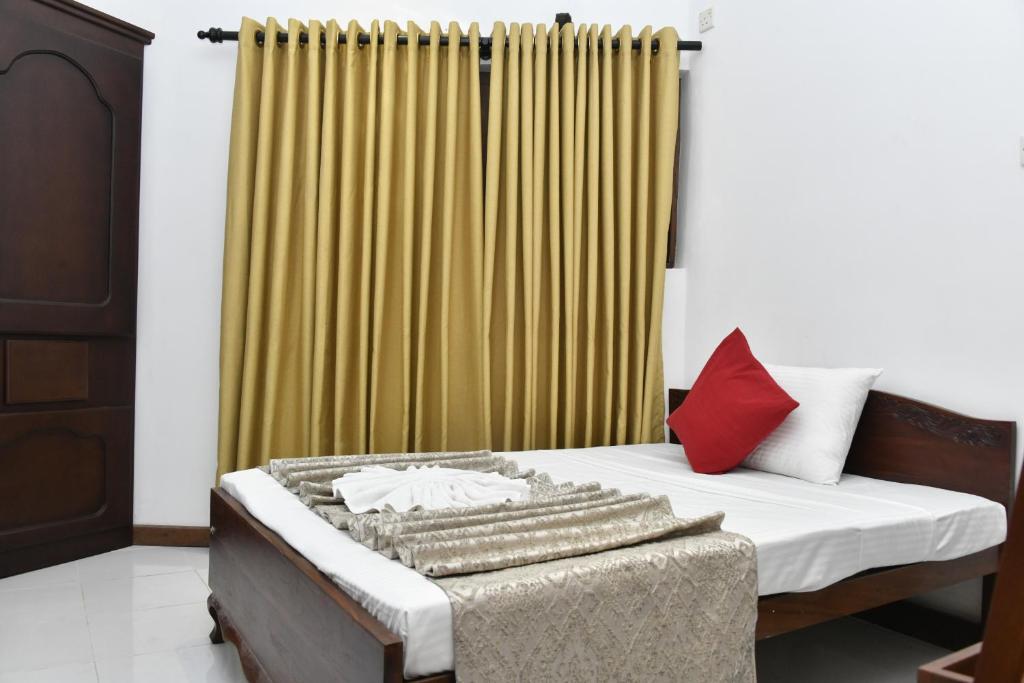 - une chambre avec un lit et un rideau jaune dans l'établissement Urban Deck, à Colombo