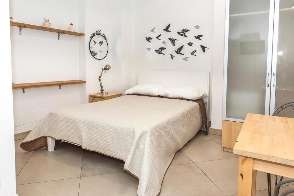1 dormitorio con 1 cama con pájaros en la pared en A23 - Monolocale in Ancona Centro sx en Ancona