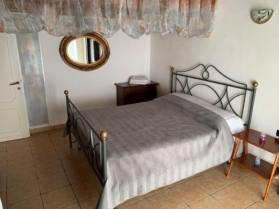 een slaapkamer met een bed en een spiegel aan de muur bij Alloggio da Mary in Canale Monterano