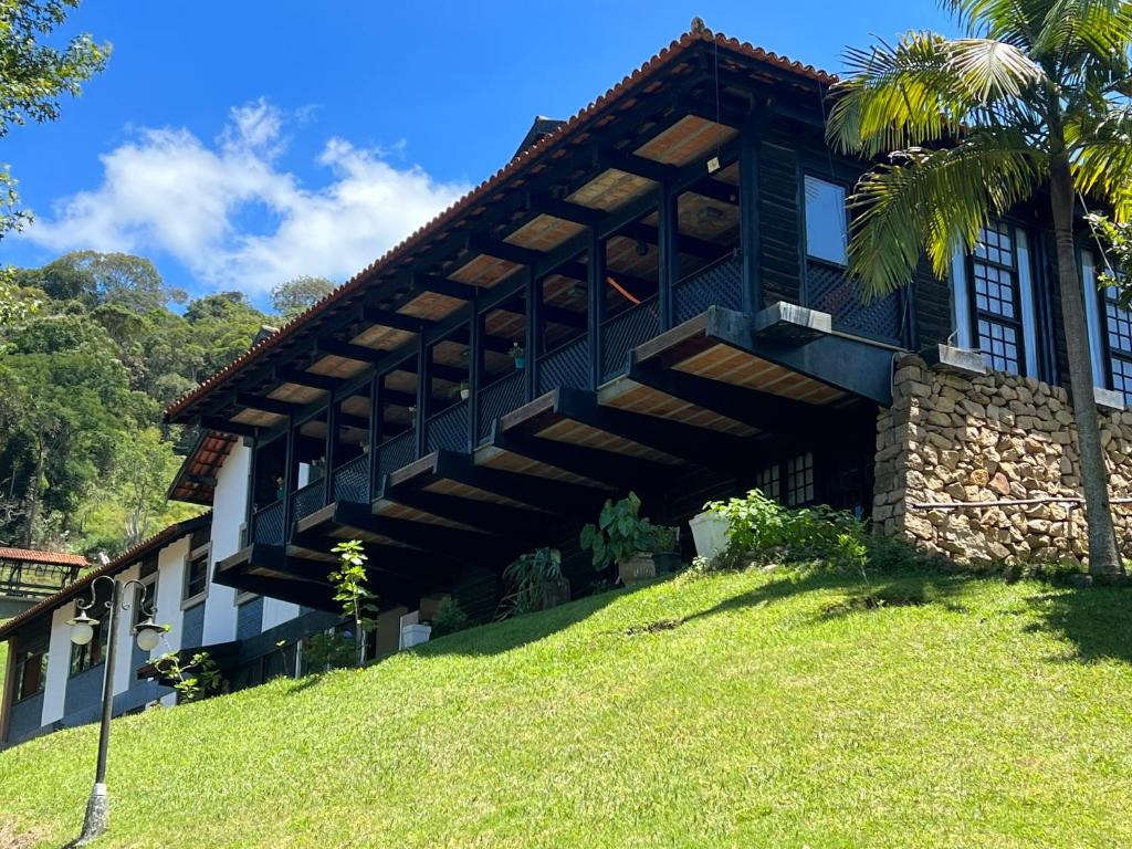 ein Gebäude auf einem Hügel mit einer Palme in der Unterkunft Casa Holanda in Teresópolis