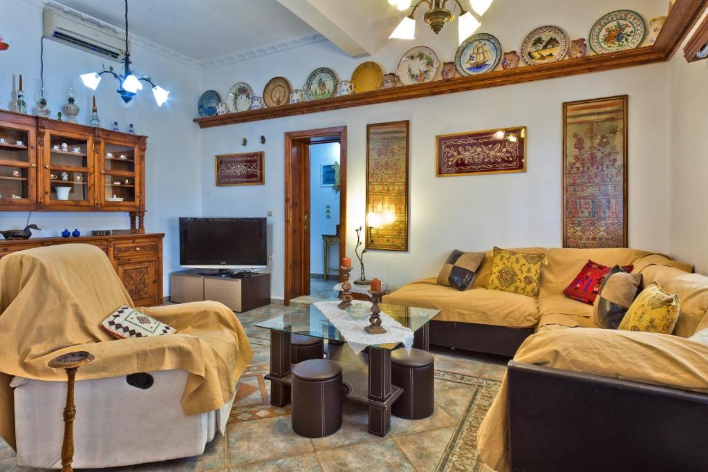 a living room with two couches and a tv at Villa Ntora in Afiartis