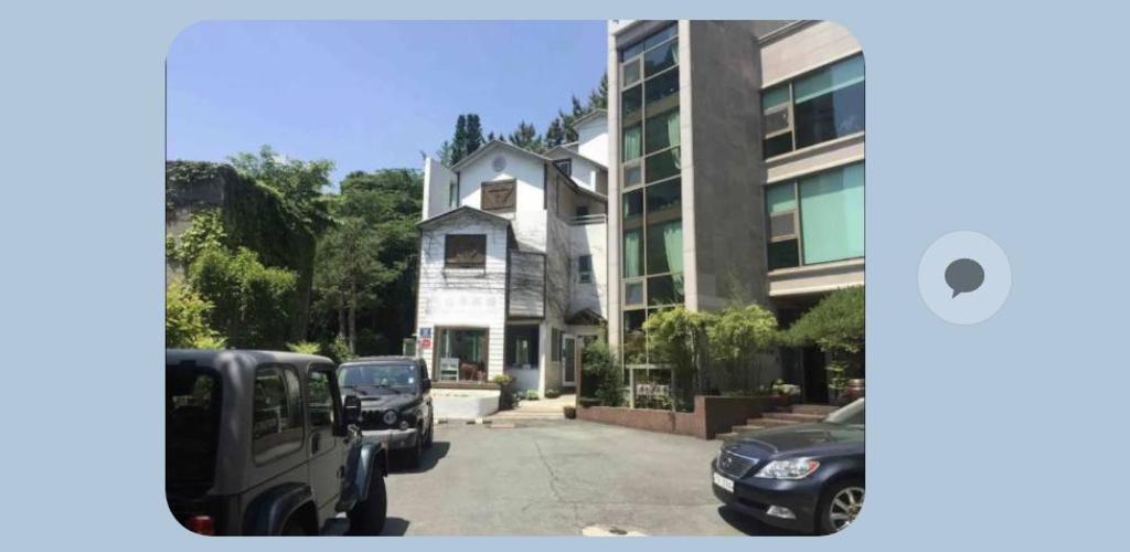 una casa con coches estacionados frente a un edificio en Art Residency en Busan