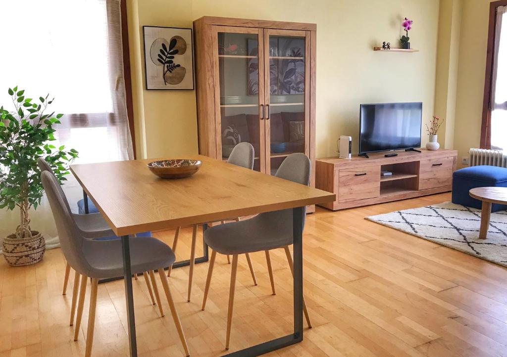 a living room with a dining room table and a television at Ekhiola Txiki in Ochagavía