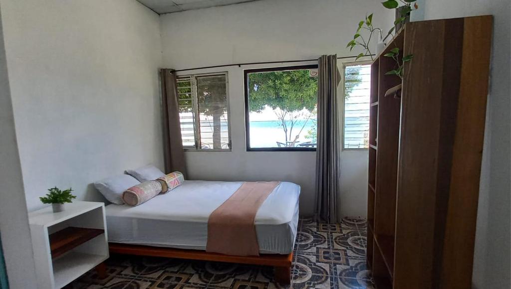 a bedroom with a bed and a large window at Bikini Beach in El Remate