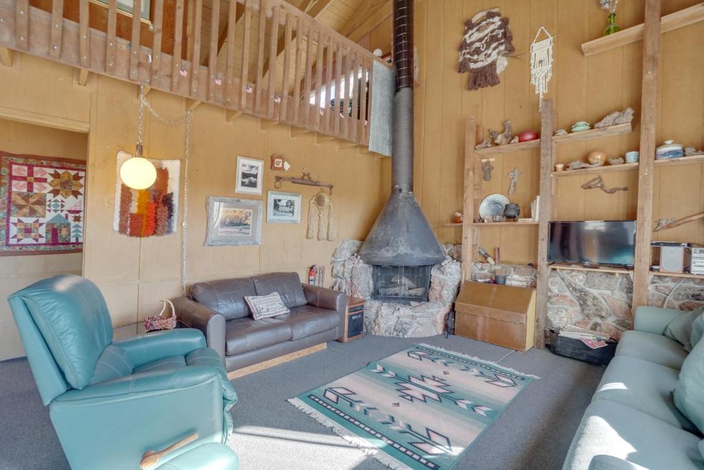 a living room with a couch and a fireplace at Red Feather Lakes Cabin with Deck and Views! in Red Feather Lakes