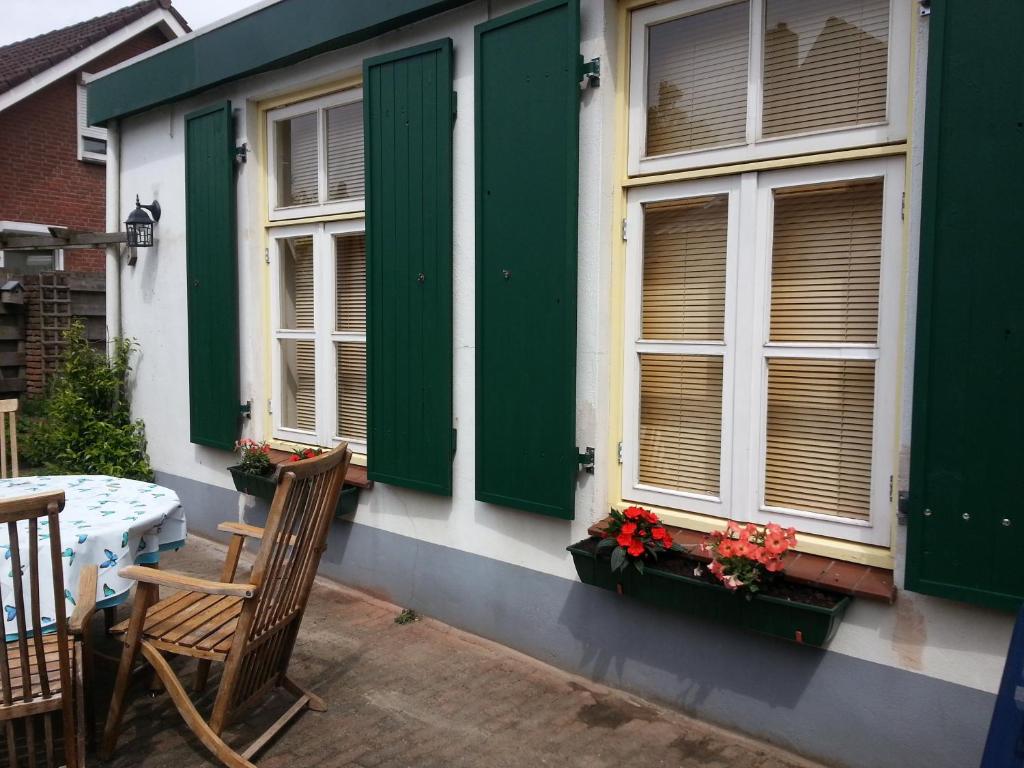 Casa con ventanas verdes, mesa y sillas en Oude woonboederij/old farmers house/typ. NL-Bauernhaus, en Zeddam