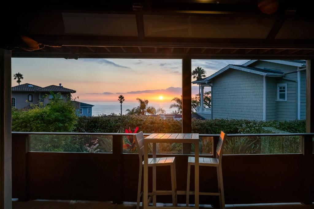 a table and chairs on a balcony with a view of the sunset at Contemporary Ocean Sunset Views with Firepit Pt Loma close to PLNU in San Diego