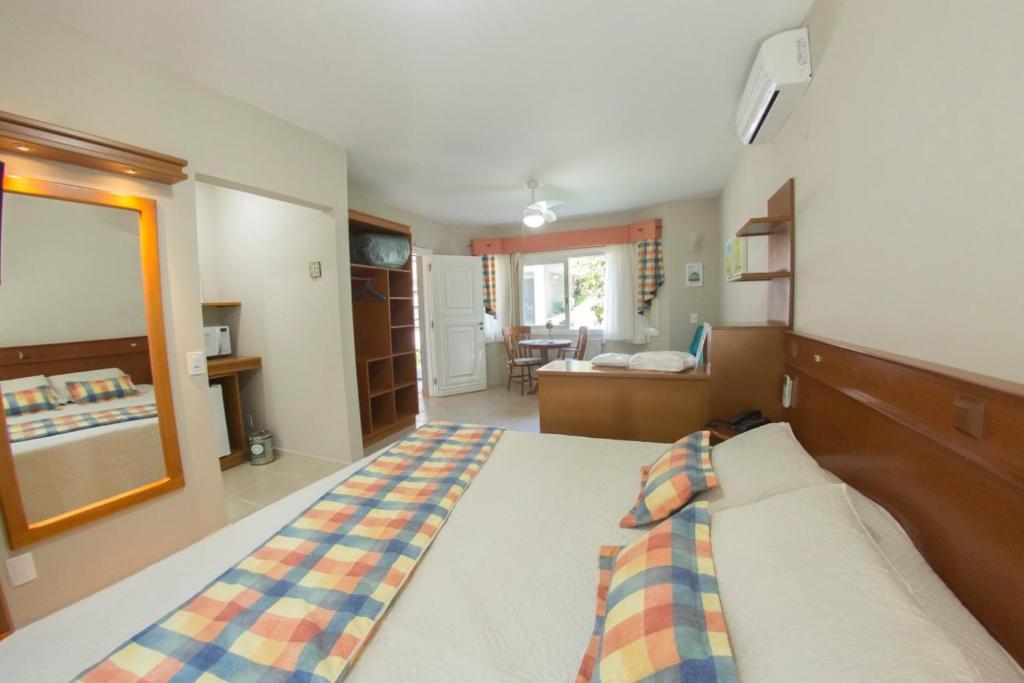 ein Schlafzimmer mit einem Bett und ein Zimmer mit einem Spiegel in der Unterkunft Hotel Cozumel Sierra in Canela
