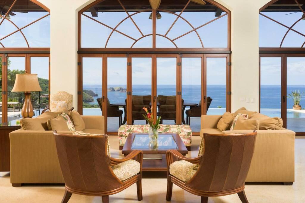 salon z 2 kanapami, stołem i krzesłami w obiekcie Casa Cinco Sinsontes w mieście Playa Hermosa