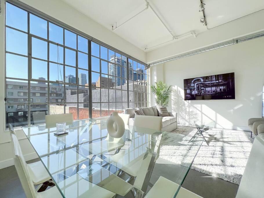 a living room with a glass table and chairs at Modern Loft in DTLA - Rooftop Pool & Free Parking! in Los Angeles