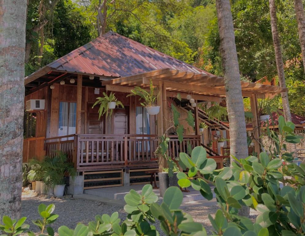 a wooden cabin in the middle of a forest at Inay’s Beachfront House in San Juan