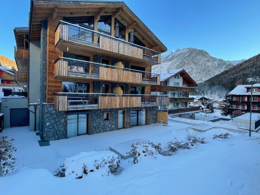 un bâtiment dans la neige avec des terrains recouverts de neige dans l'établissement Berghof, à Saas-Fee