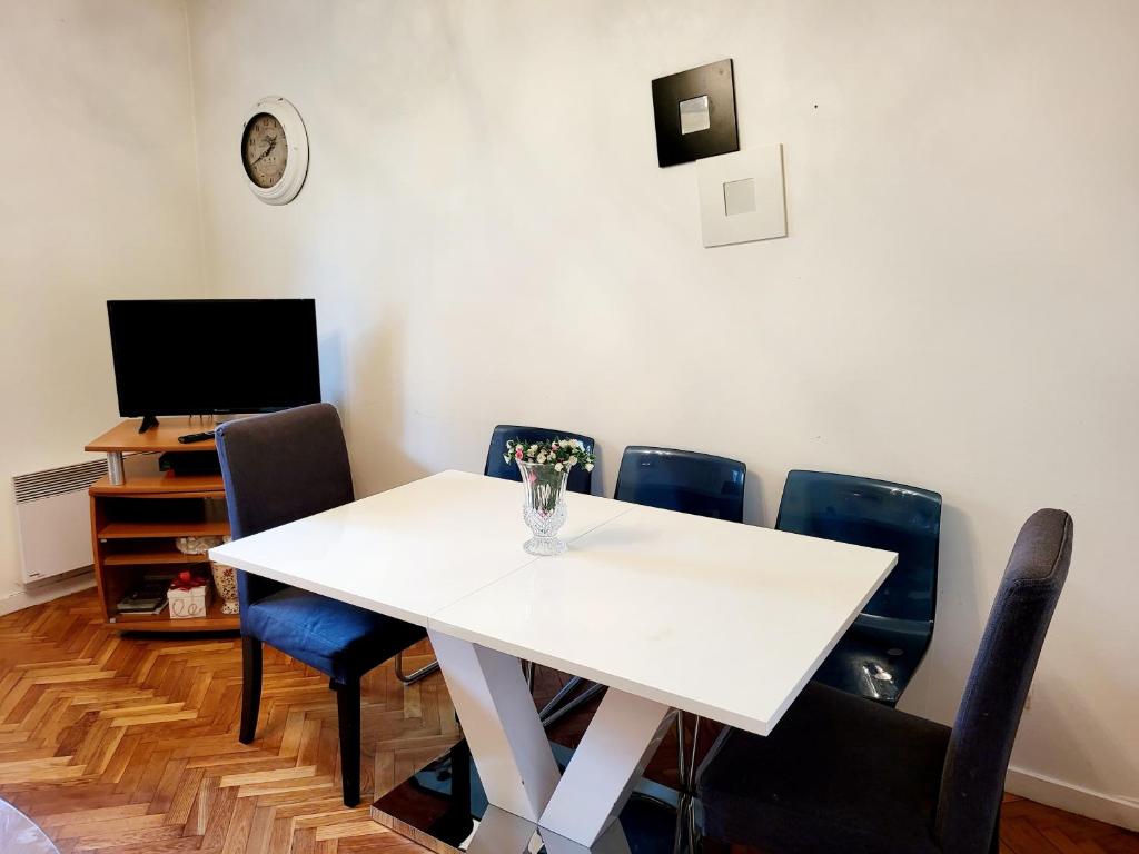 una camera con tavolo e sedie bianchi di Superbe appart 2 pièces -accès autonome- avec parking gratuit a Chaville