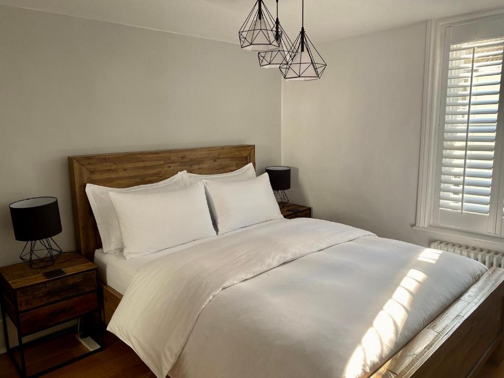 a bedroom with a white bed and a window at Camelford Street Cottage - Brighton in Brighton & Hove