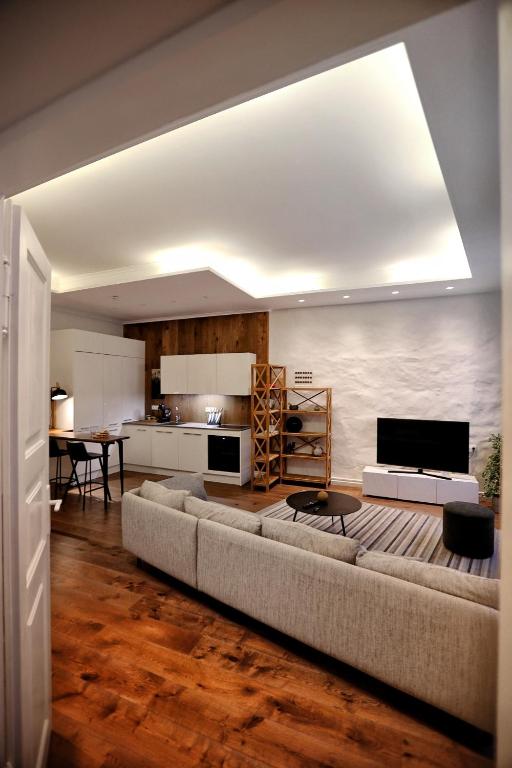 Town Hall Square Apartment في تالين: غرفة معيشة بها أريكة كبيرة ومطبخ