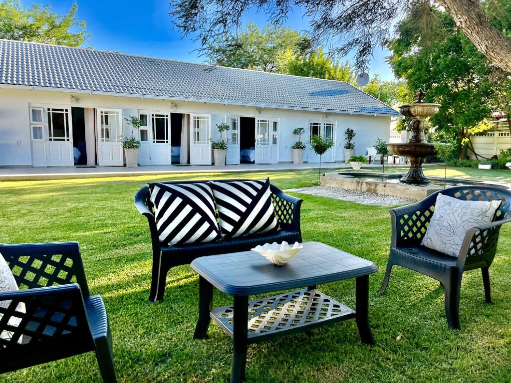 un grupo de sillas y una mesa en un patio en VIilla Vredenrust Guesthouse, en Bloemfontein