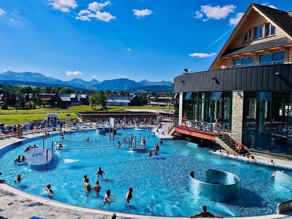 un grupo de personas en una piscina en un complejo en Tatra Village, en PyzÃ³wka