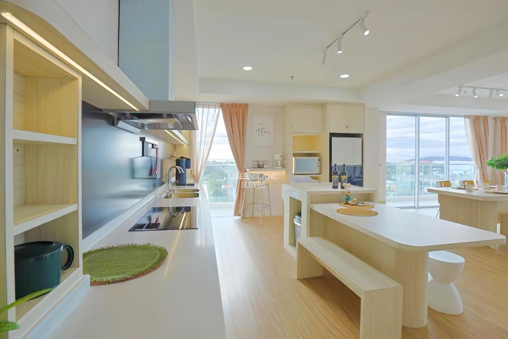 a kitchen with a white counter and a kitchen island at QUEENSLAND SUITES at Aru Suites, Kota Kinabalu in Kota Kinabalu