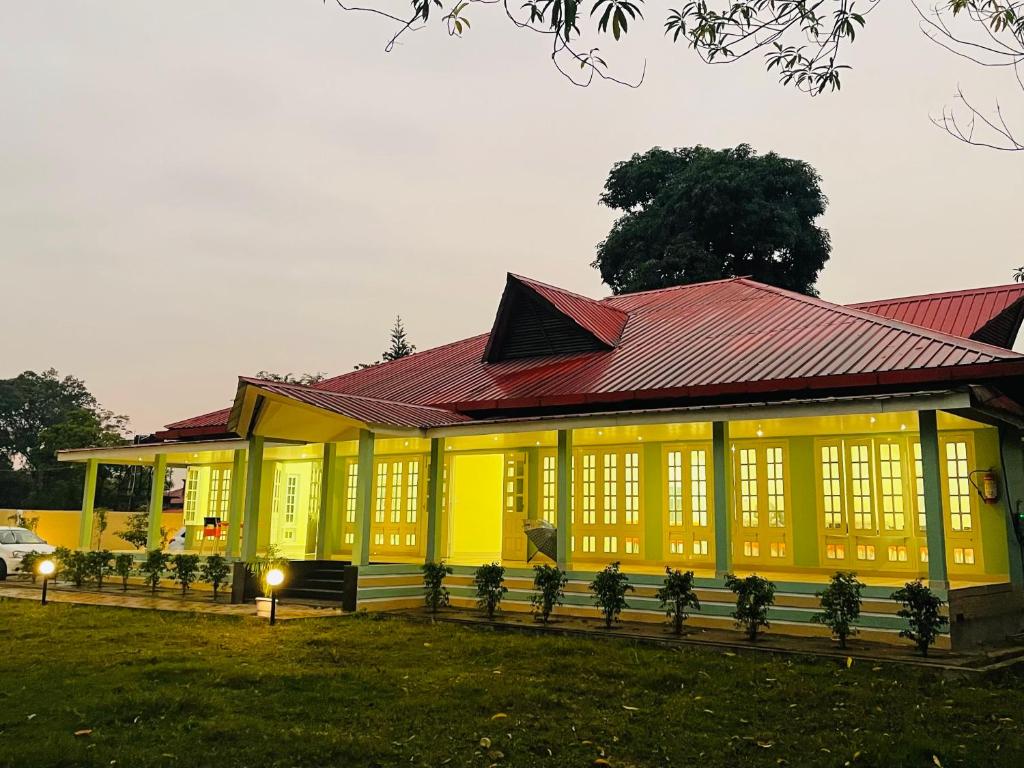 a yellow building with a red roof at Green Paradise Hotel and Resort in Narjon Basti