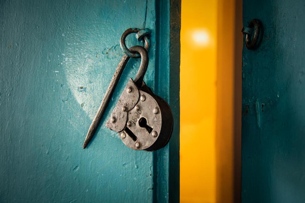 a door with a padlock on a blue door at Posada del Campanario in Barichara