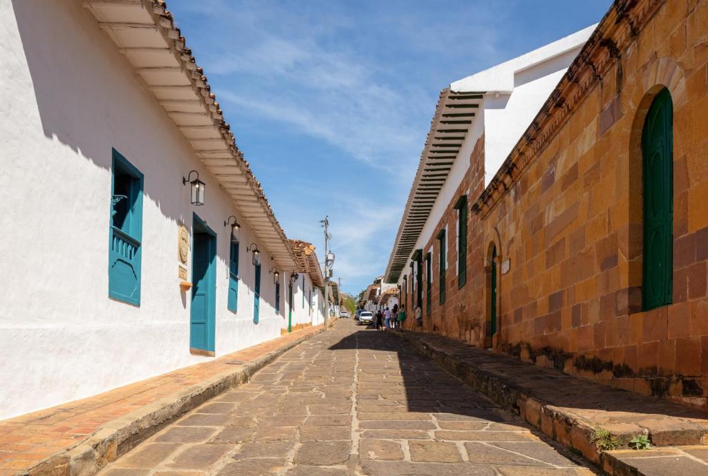an empty street in an alley with buildings at Posada del Campanario in Barichara