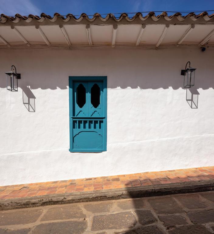 a door with a face painted on the side of a building at Posada del Campanario in Barichara