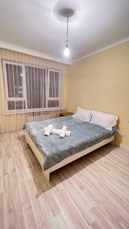 a bedroom with a bed with two towels on it at 3 комнатная квартира Бесагаш Сити in Almaty