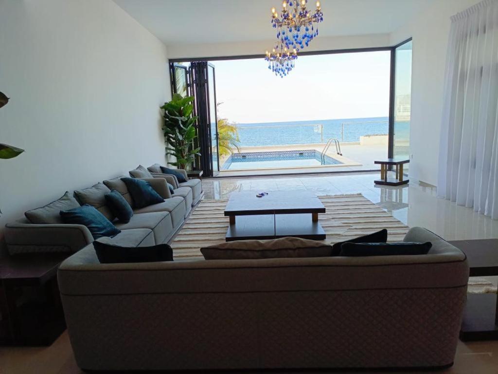 a living room with a couch and a view of the ocean at Oceanfront Villa 5BHK with private pool and seaview in Fujairah