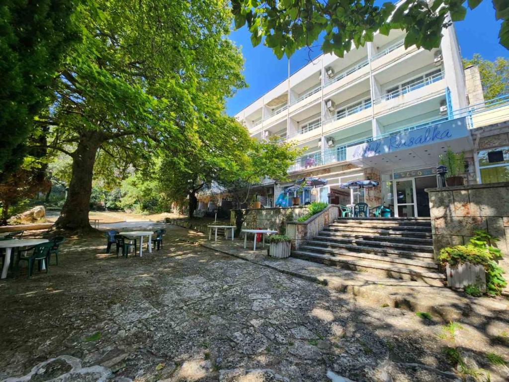 un bâtiment avec des tables et des chaises devant lui dans l'établissement park-hotel Rusalka, à Varna