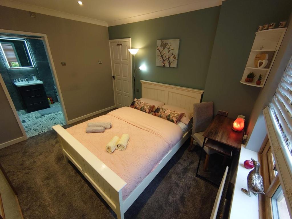 sypialnia z łóżkiem z dwoma ręcznikami w obiekcie Lovely room with ensuite in a quiet house w mieście Rayleigh